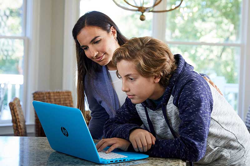 mom and son with laptop at kitchen counter